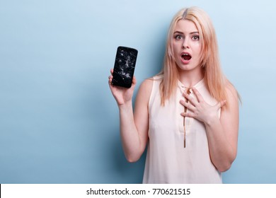 Girl shocked with a broken phone in her hand against a blue background