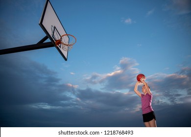 Girl Shooting A Basketball At An Outdoor Court