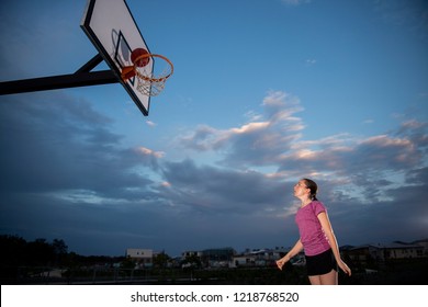 Girl Shooting A Basketball At An Outdoor Court
