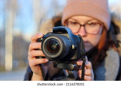 The girl shoots with a camera, a photo with a SLR camera, the girl shoots a video