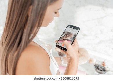 A girl shoots content on her phone for a culinary blog - Powered by Shutterstock