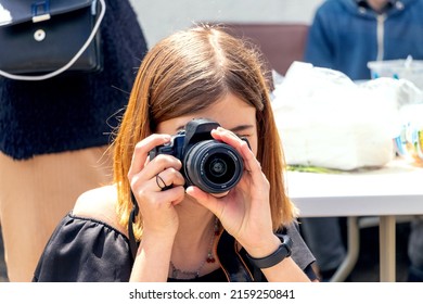 The girl shoots people with a SLR camera
