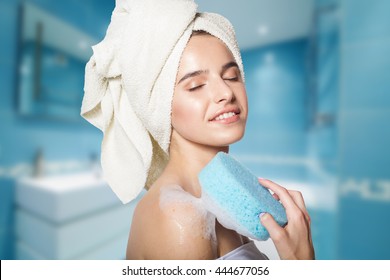 Girl in shower with blue bath sponge