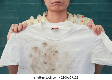 Girl Showing Dirty Stain On Kid Shirt With Bad Feeling From Playing Hard On Mud Stain. Dirty Stain For Cleaning Concept Work.