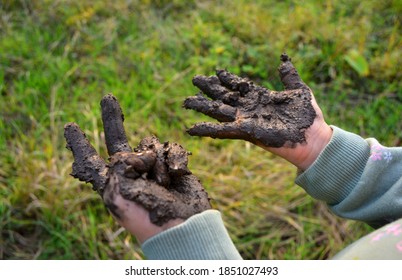 Girl Showing Muddy Hands Outdoors