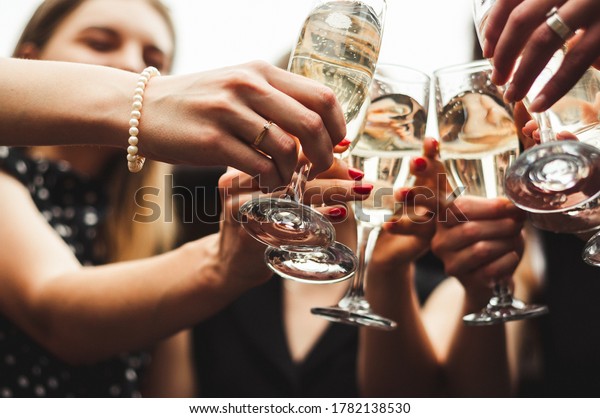 The girl shows an engagement ring on her\
finger. Happy wedding day. Pre-wedding party. Chilling Together.\
Girls party. Glasses of\
champagne
