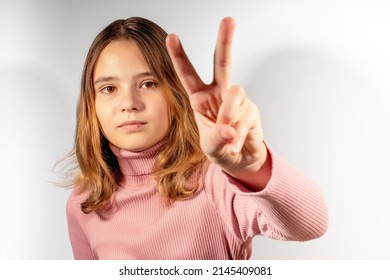 The girl shows the gesture of victory. A self-confident teenager is ready to defend his rights. The concept of the problems of the younger generation.