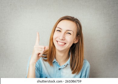girl shows the index finger up and smiling