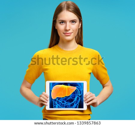 Girl shows the x-ray image of the liver. Photo of young girl with tablet in her hands on blue background. Medical concept