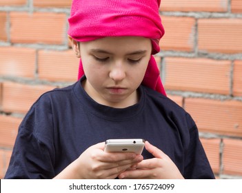 Girl Sick With Cancer And With A Headscarf Using The Mobile Phone