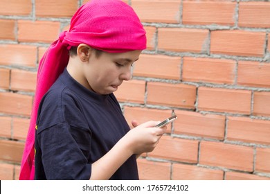 Girl Sick With Cancer And With A Headscarf Using The Mobile Phone