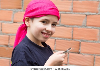 Girl Sick With Cancer And With A Headscarf Using The Mobile Phone