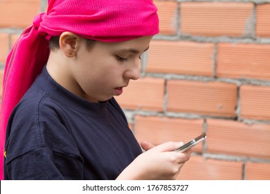 Girl Sick With Cancer And With A Headscarf Using The Mobile Phone