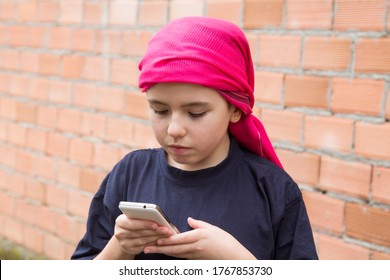 Girl Sick With Cancer And With A Headscarf Using The Mobile Phone