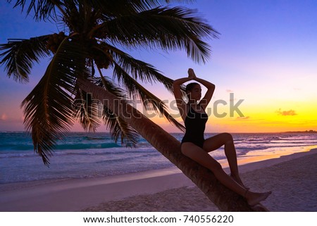 Girl silhouette on palm tree Caribbean sunset beach of Riviera Maya Mexico