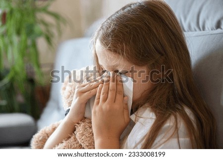 the girl sits hugging a soft toy and sneezes. Allergy to house dust mites Сток-фото © 