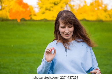 the girl sits on the field and the wind blows her hair - Shutterstock ID 2274437259