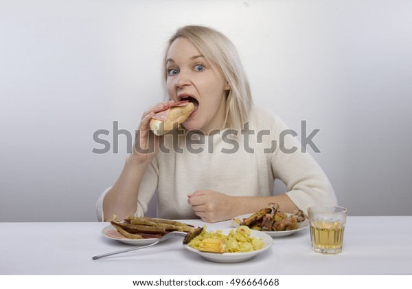 女の子は食卓に座って食べる ジャンクフード 貧しい食事 過食 拒食症 食事 痩せ衰え の写真素材 今すぐ編集