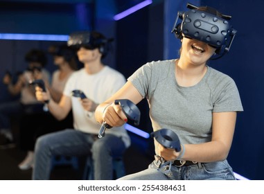 Girl sits in virtual reality glasses controls superhero with joystick in exciting action game simulator.testing virtual reality device in digital world - Powered by Shutterstock