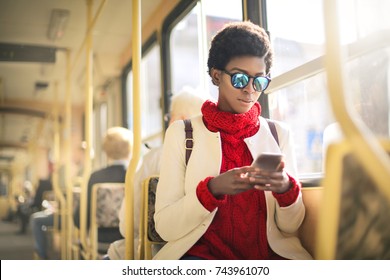 Girl Sitting In A Bus, Using Her Smart Phone
