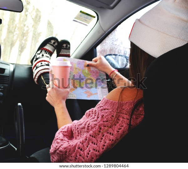 Girl sitting in a car with\
coffee