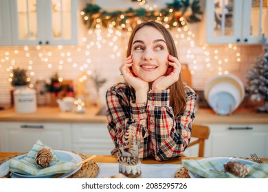 Girl Sitting In Christmas Decorated Kitchen And Thinking