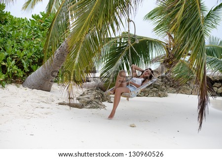 A girl sitting and dreaming in a hammock in Maldives