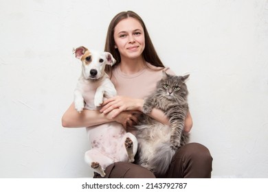The girl is sitting with her cat and dog - Shutterstock ID 2143792787