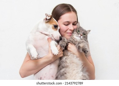 The girl is sitting with her cat and dog - Shutterstock ID 2143792789