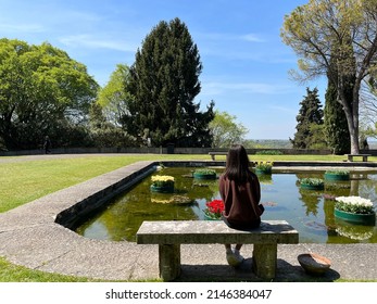 girl sitting on a bench looking at nature park 