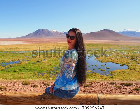 Girl is sitting on the bench near the river, Atacama Desert, San Pedro de Atacama, Chile