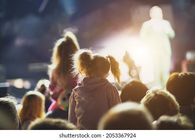 Girl Sitting On Daddy's Shoulders At A Street Concert.