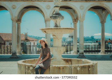 Girl sitting on the fountain. Portugal, Lisbon.