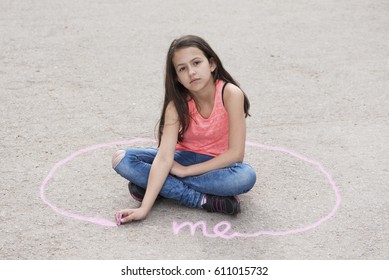 Girl Sitting On The Ground And Drawing Personal Space. Selective Focus