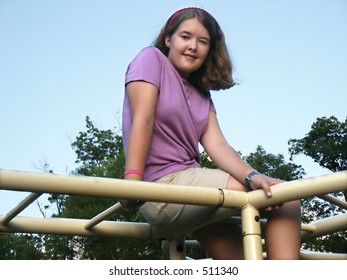 Girl Sitting On Monkey Bars