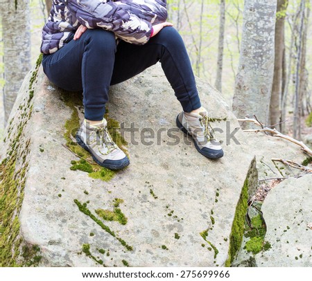 girl sitting on a rock in the woods