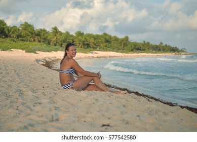 A girl sitting on the shore, Xcacel beach, Playa del Carmen, Mexico