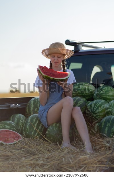 The girl is sitting on watermelons\
in the car. Eating a watermelon. Summer. Autumn. Harvesting.\
Environmentally friendly products. Agriculture.\
Farming.