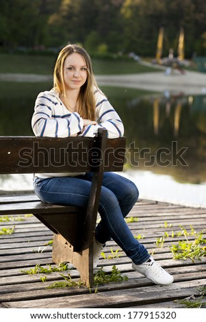 girl sitting outdoors on the lake background