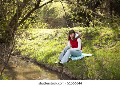 Girl sitting and resting near a river - Shutterstock ID 51566644