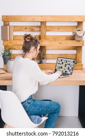 Girl Sitting At Table With Laptop With Loaded Pinterest Page