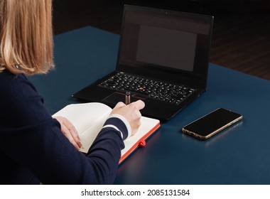 The Girl Is Sitting At A Table With A Laptop. No Body. Remote Access Concept. Close-up. Selective Focus