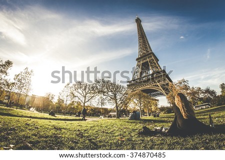 A girl sitting under the Eiffel Tower, Paris