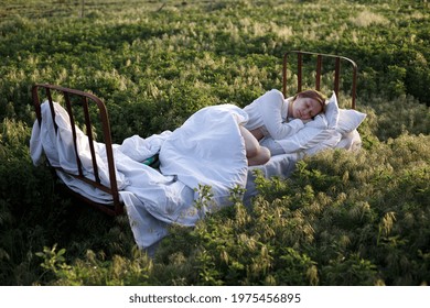 Girl Sleeping In The Bed In A Green Field. Healthy Sleep In Nature
