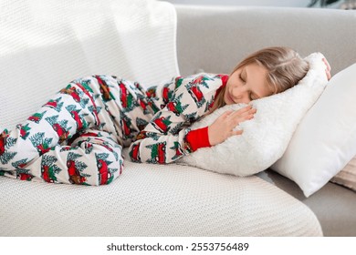 Girl sleeping on a cozy couch in festive pajamas. A young girl peacefully sleeping on a soft white pillow and blanket on a couch, dressed in festive pajamas. - Powered by Shutterstock