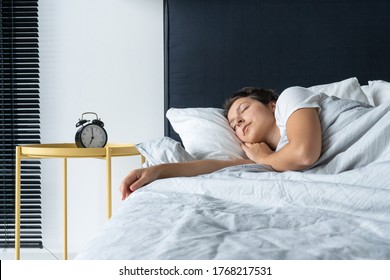 The Girl Sleeps Next To The Alarm Clock. Time To Wake Up. On The Wake-up Clock 7 A.m. Deep Sleep