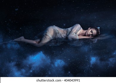 Girl Sleeps In Space Among Stars Night Sky Fantastic Fotoshoot Creative Color. Dark Blue Northern Lights. Sleeping Beauty Zodiac Sign Galaxy Shine Lights Sparkle. Young Beautiful Woman Dream Fantasy 