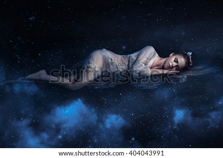 Girl sleeps in space among stars night sky fantastic fotoshoot creative color. dark blue northern lights. Sleeping Beauty Zodiac sign Galaxy Shine lights sparkle. young beautiful woman dream fantasy 