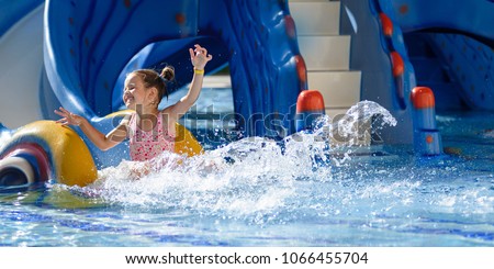 Girl Sliding in pool during vacations summer holiday
