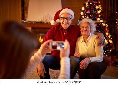 Girl With Smartphone Taking Picture Grandparents On Christmas Eve
